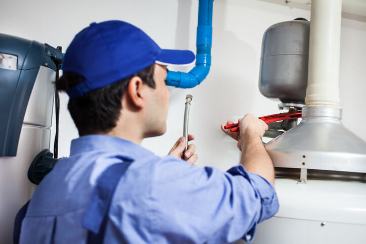 technician repairing a water heater