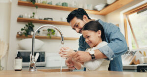 Dad and child using kitchen sink